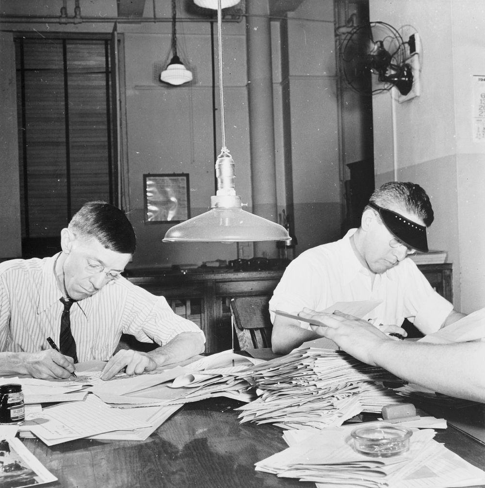 New York, New York. Newsroom of the New York Times newspaper. Copyreaders at the foreign desk. In foreground, foreign desk…