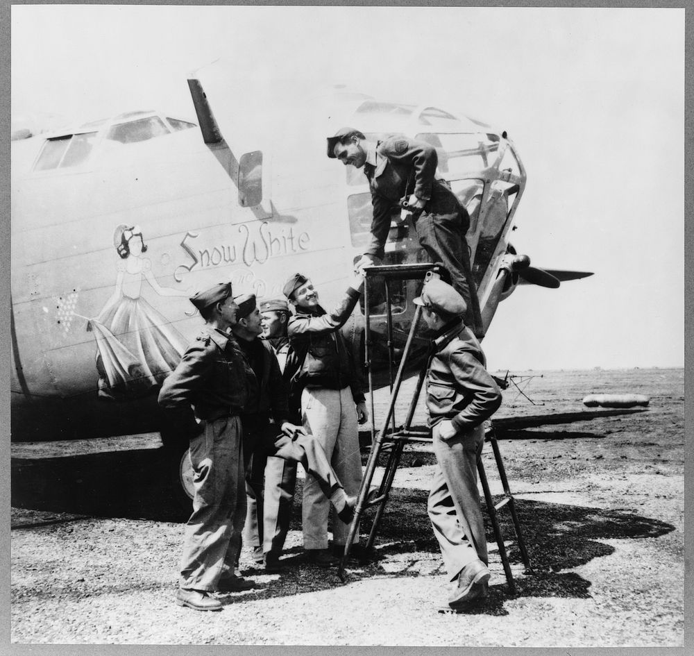 Snow White, a B-24 bomber of the U.S. Army 9th Air Force at a forward bomber base in the Libyan desert. Among its crew…