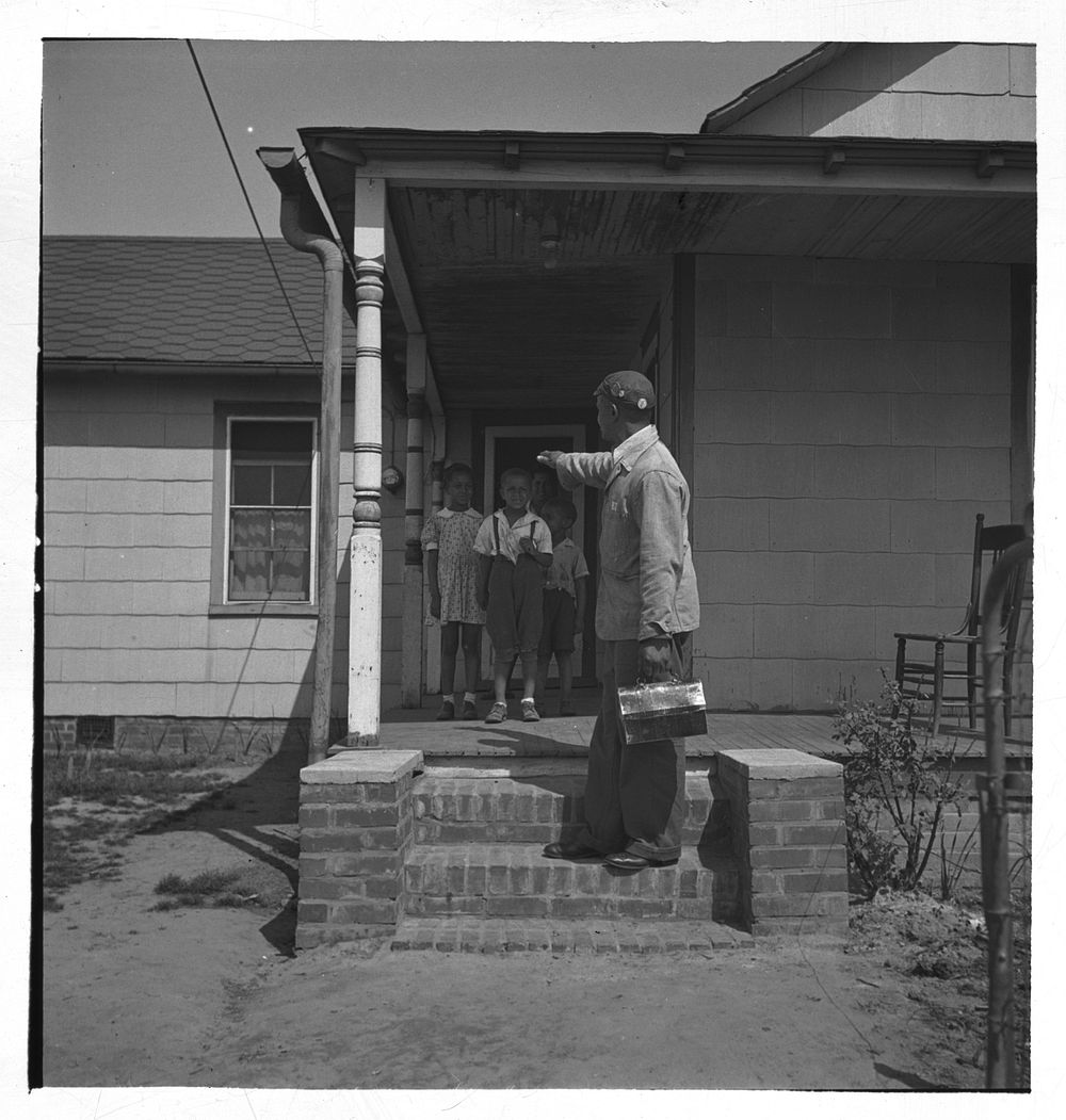 Newport News, Virginia.  shipyard worker leaving his rural home for the shipyards with his lunch box. Sourced from the…