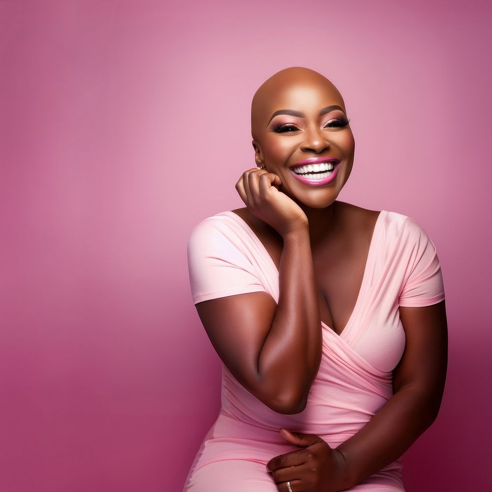 close up face photo of a bald chubby black woman smiling with pink tone makeup.  