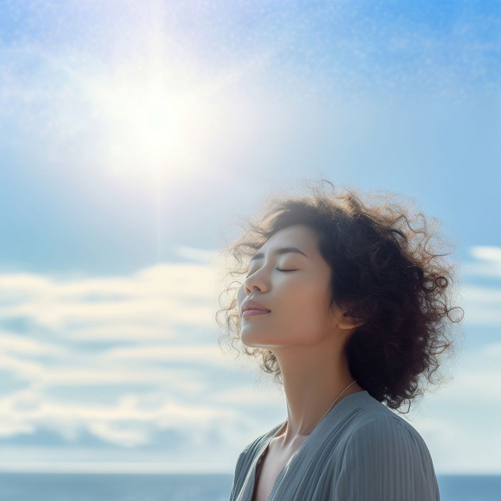 photo of woman praying with bluesky on the sea with blurred vision.  