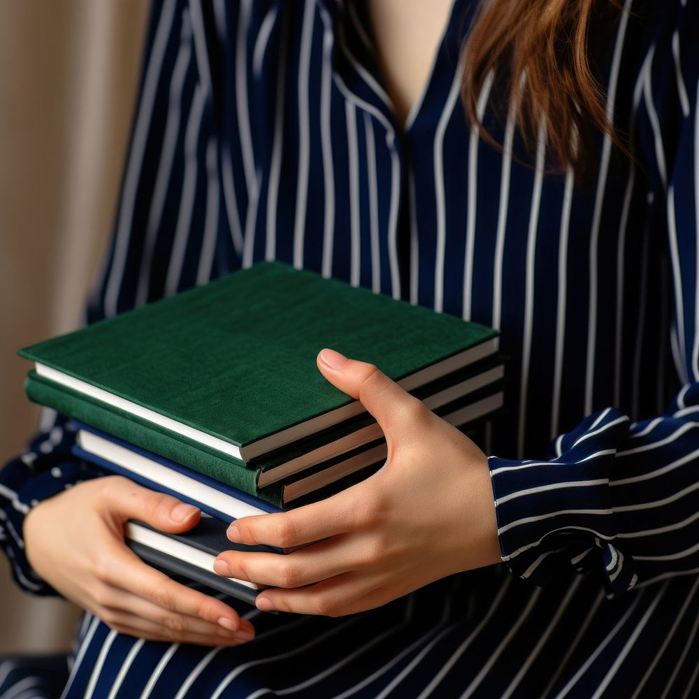 Woman holding stacked books. 