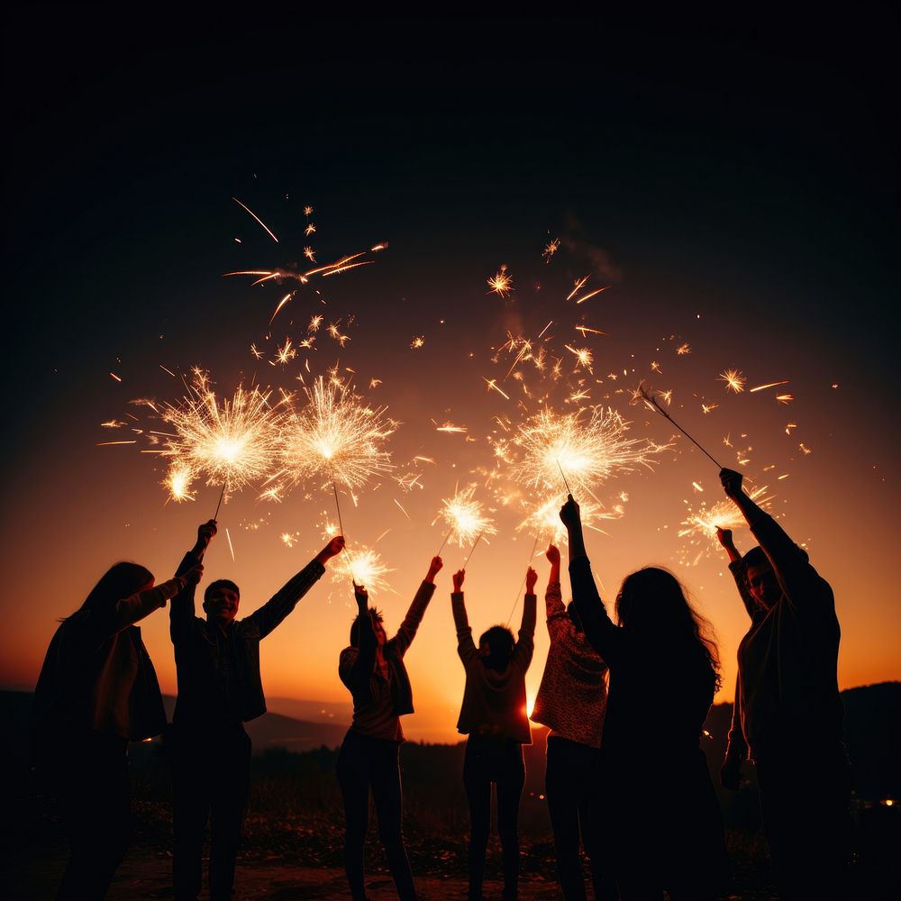 People celebrating New Year fireworks sparkler outdoors. 