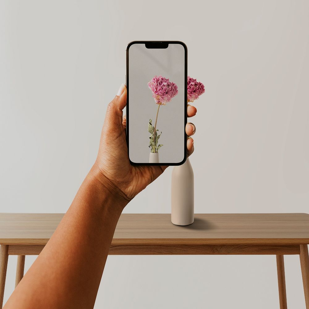 Smartphone screen mockup psd, person taking a photo of flower in a vase with phone camera