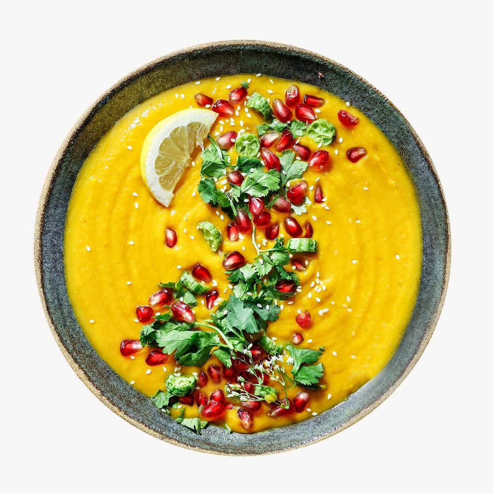 Fresh pumpkin soup topped with parsley and pomegranate seeds isolated image