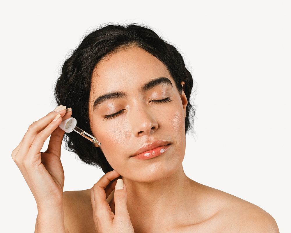 Young woman applying serum on her face isolated image