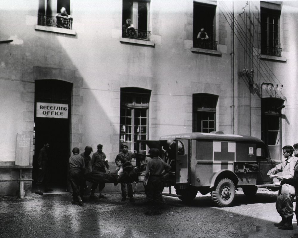 A wounded American soldier is taken from an ambulance into the receiving room of a hospital in France (1944) .Original…