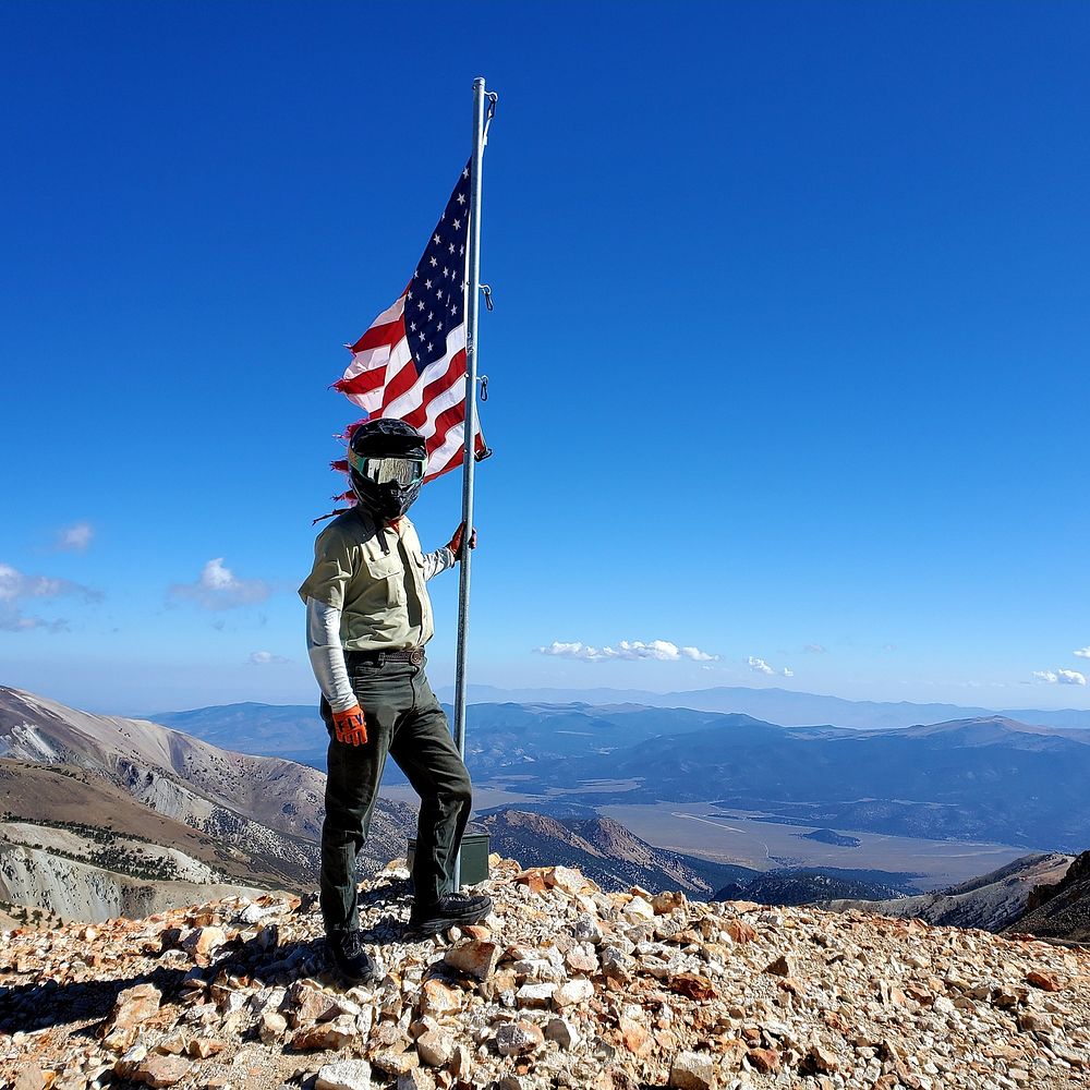 Summit Flag Humboldt oiyabe NF Christopher CoblerSpecial Use Permit Administrator Alex Van Raalte stands resolute with the…