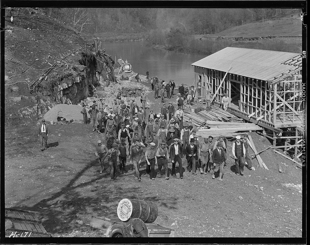 Workers returning from construction on the new bridge at Norris Dam site at noon hour, November 1933. Photographer: Hine…