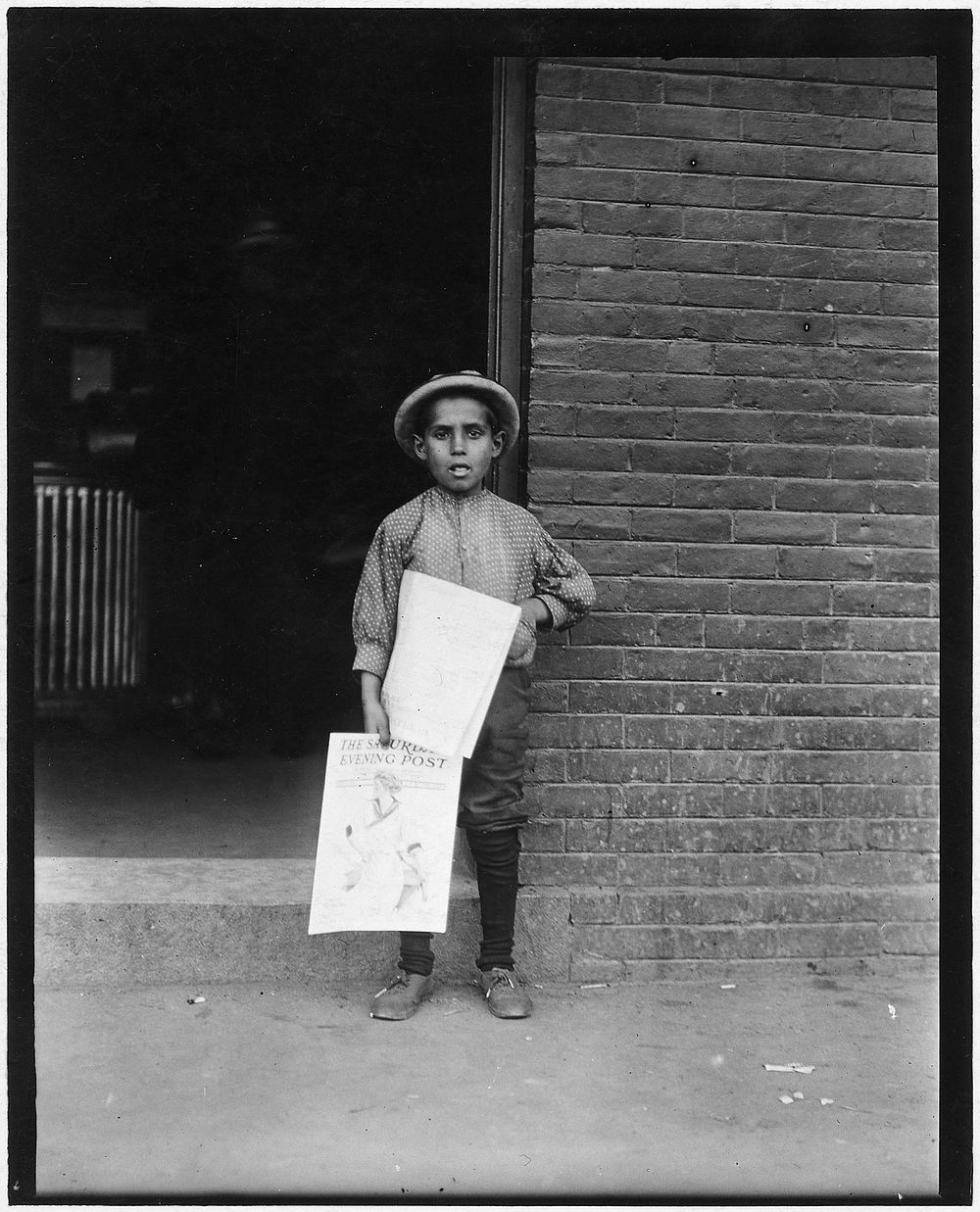 Small Newsie at depot. Burlington, Vt, September 1910. Photographer: Hine, Lewis. Original public domain image from Flickr