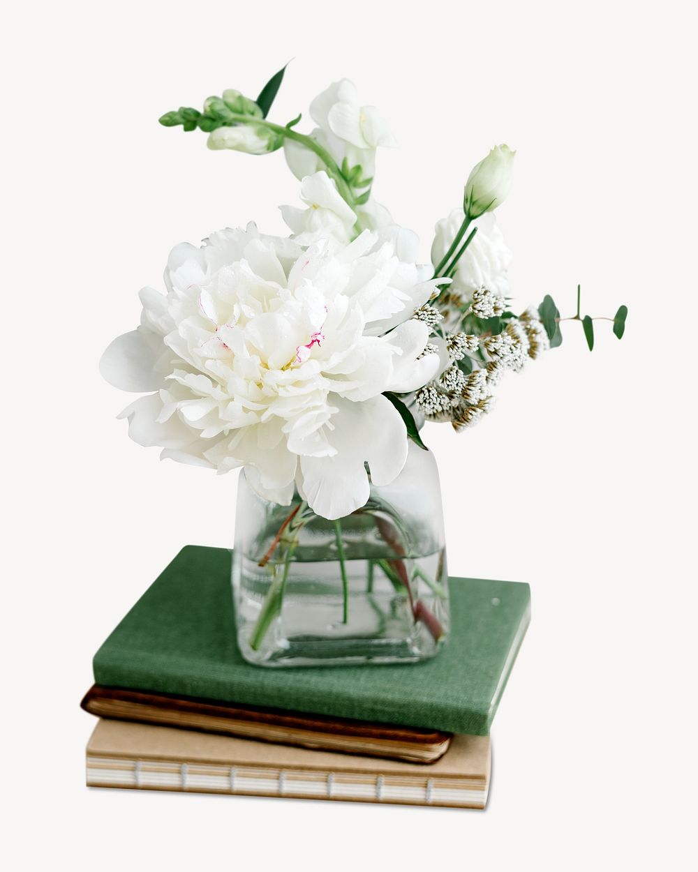 White flower in a vase on a stack of books