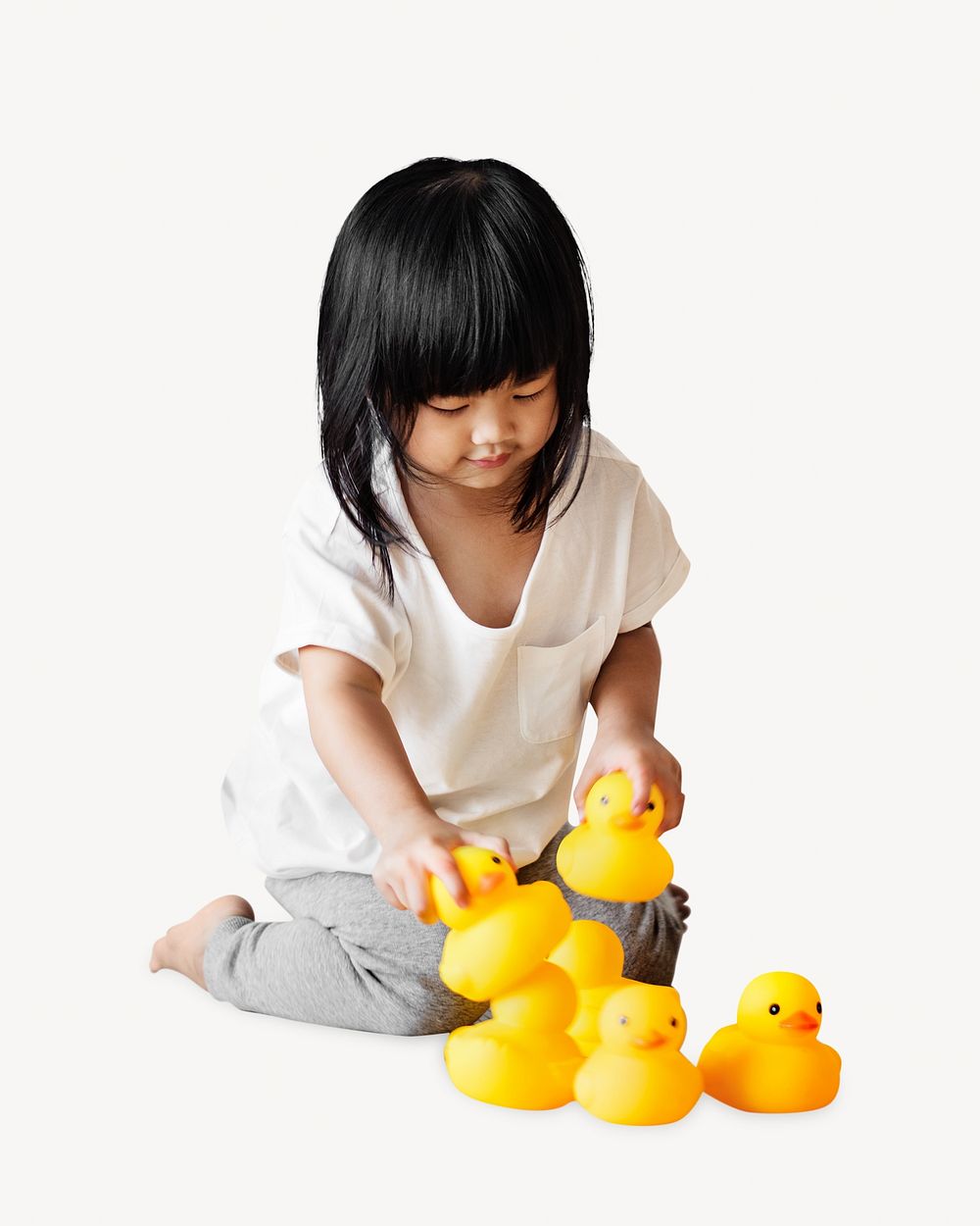 Little girl playing with rubber ducks, isolated image