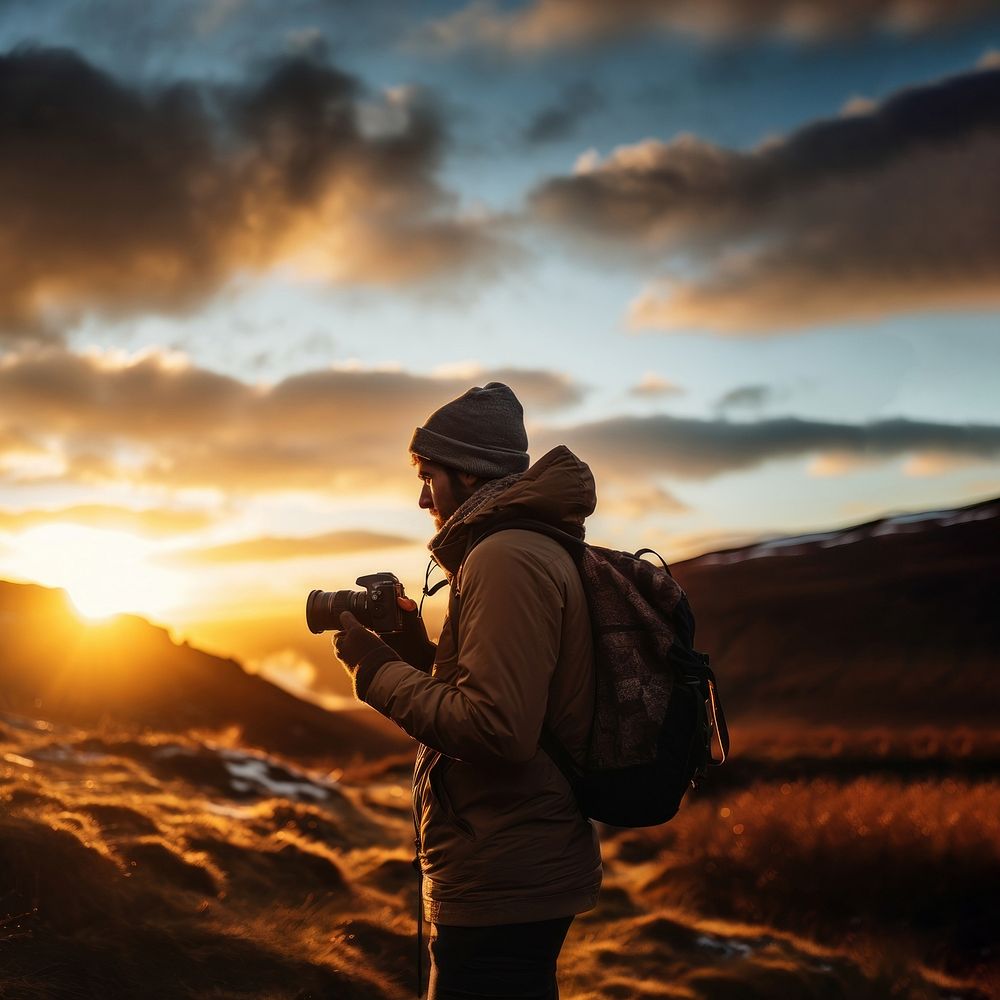 front-left view Photo of a man holding camera, taking picture in the wild in a chilly day. 