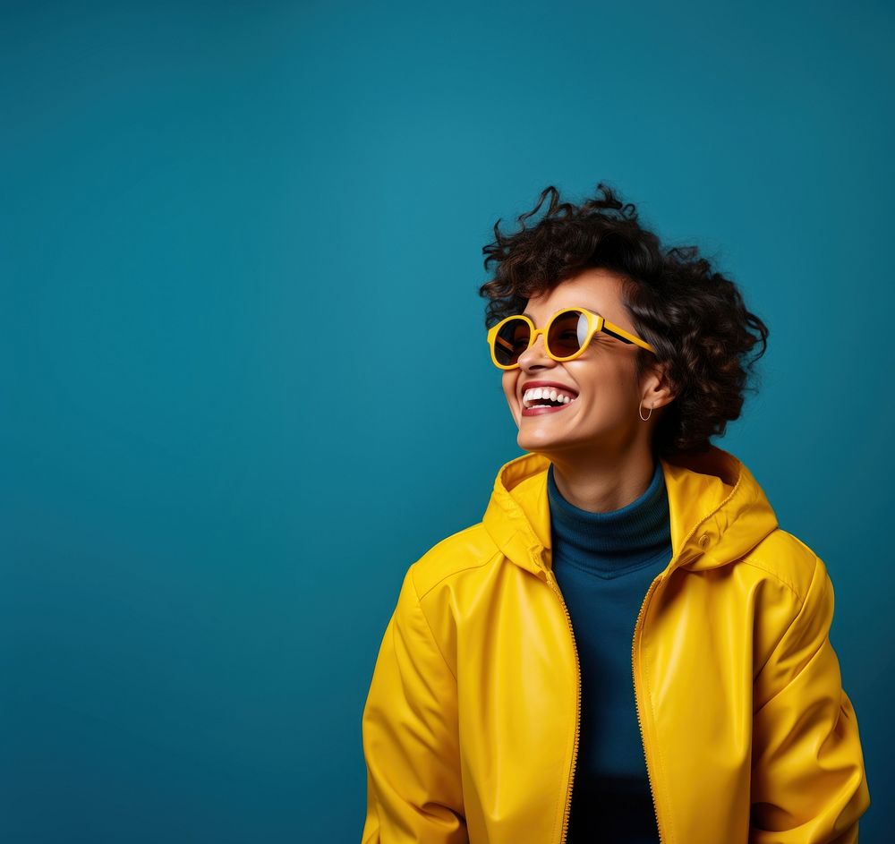 A woman wearing glasses jacket laughing yellow. AI generated Image by rawpixel.