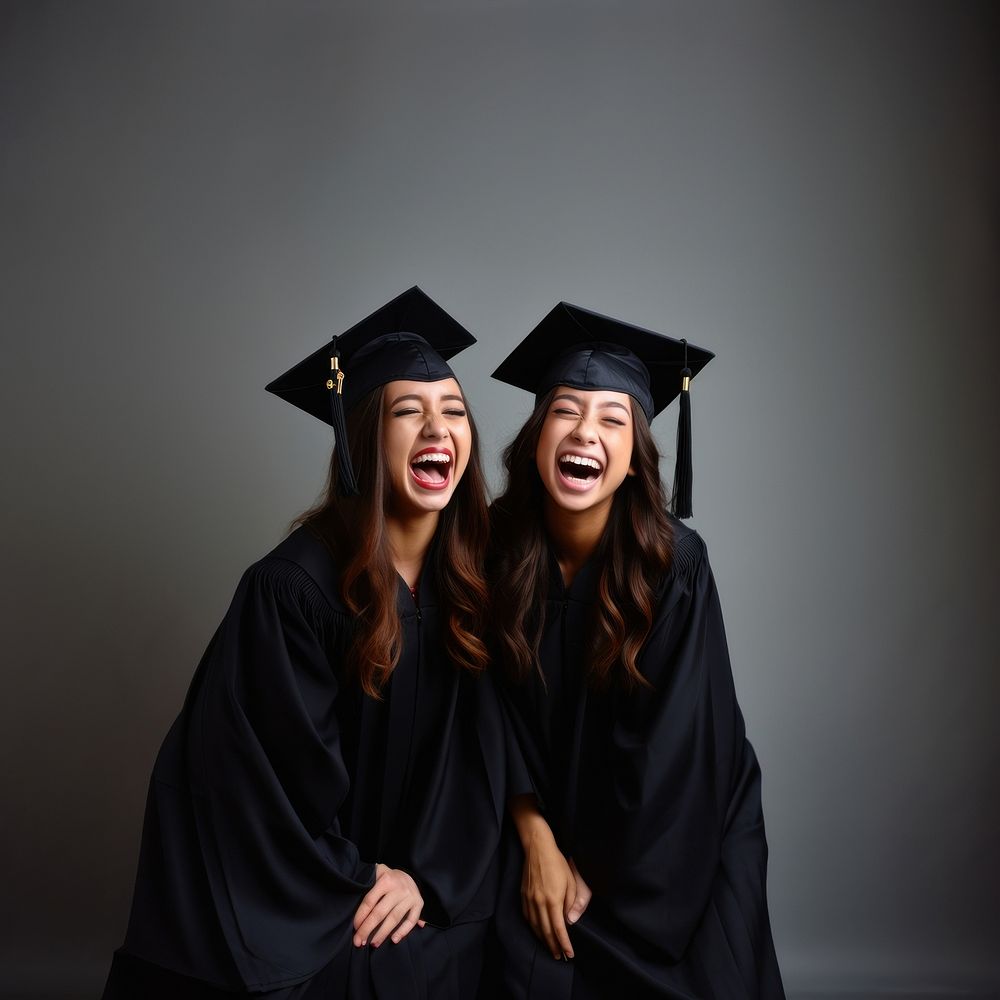 Students wearing graduation caps laughing portrait adult. 