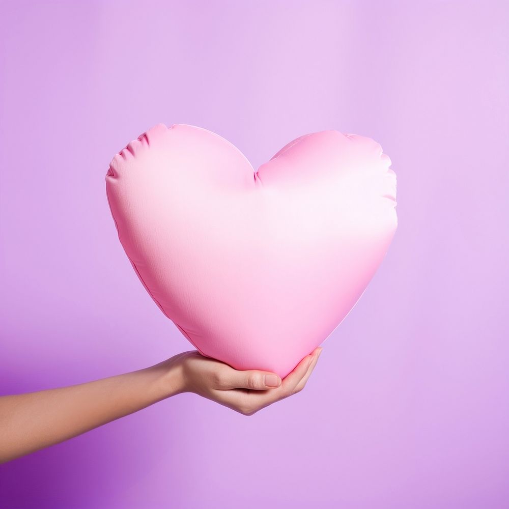 Hand holding big heart pillow balloon celebration romance. AI generated Image by rawpixel.
