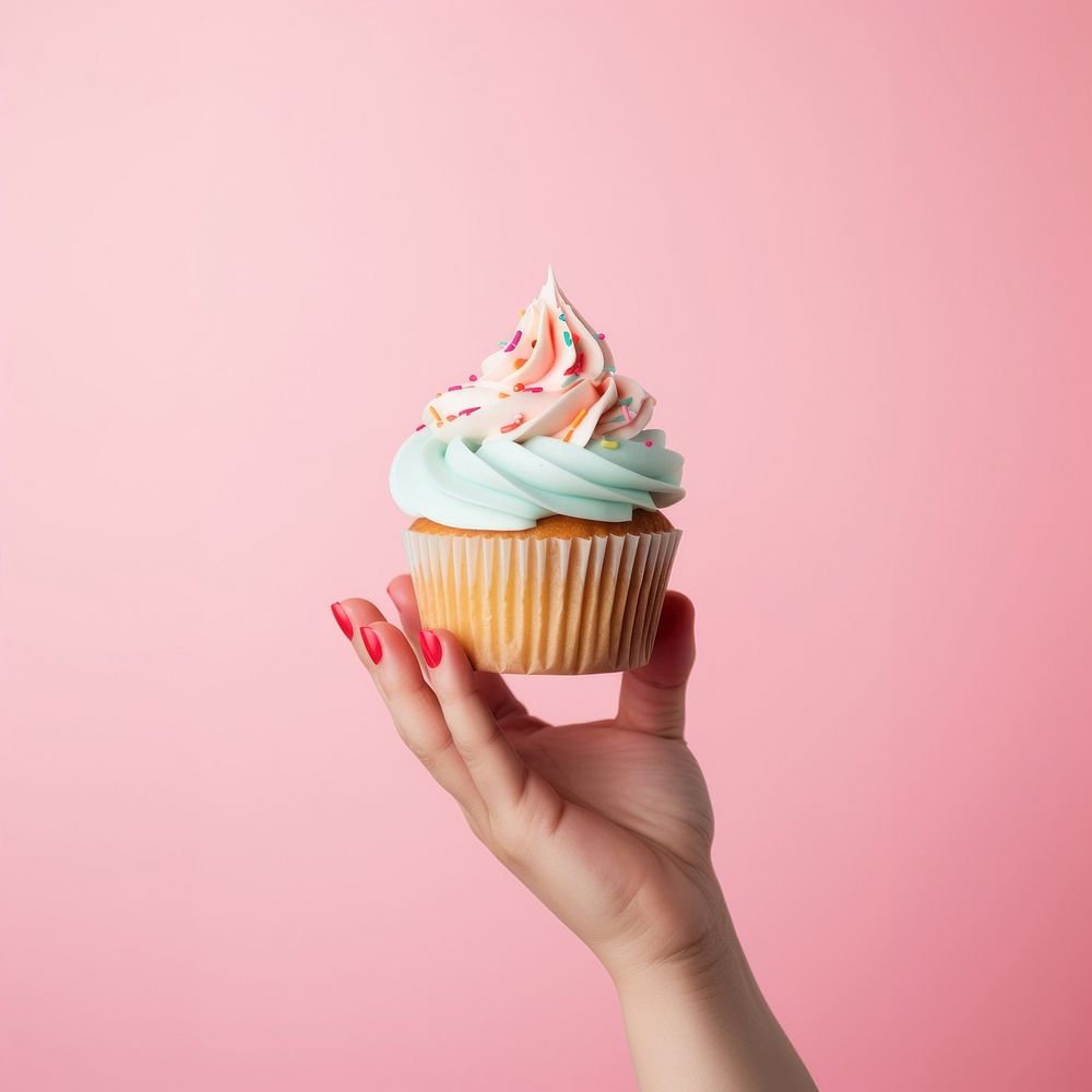 Hand holding birthday cupcake dessert cream food. AI generated Image by rawpixel.