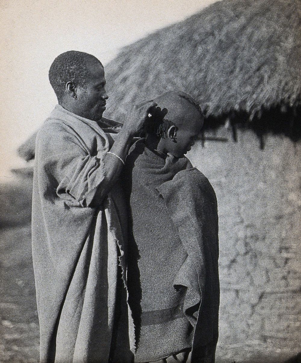 South Africa: a Pondo man attends to the hairstyle of a fellow man. Photograph, ca. 1900.