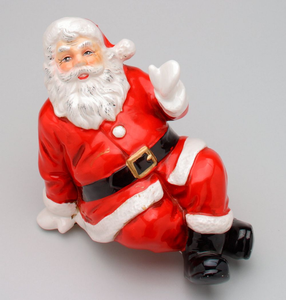 seated Santa Claus figure, made to sit with legs hanging from ledge; smiling Santa waves with PL hand; feet crossed.…
