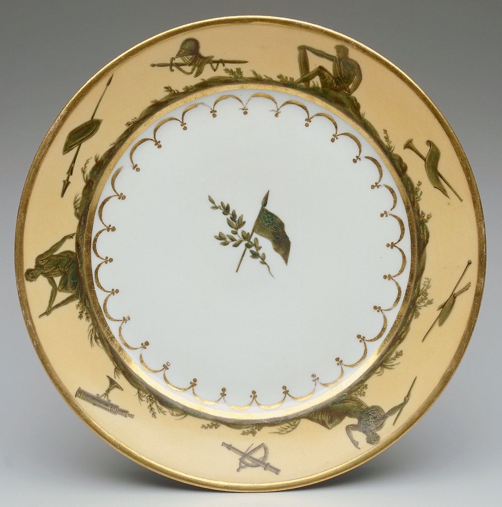 Cream rim background; porcelain dinner plate, gold rim and band at interior; rim decorated by landscape scene; seated…