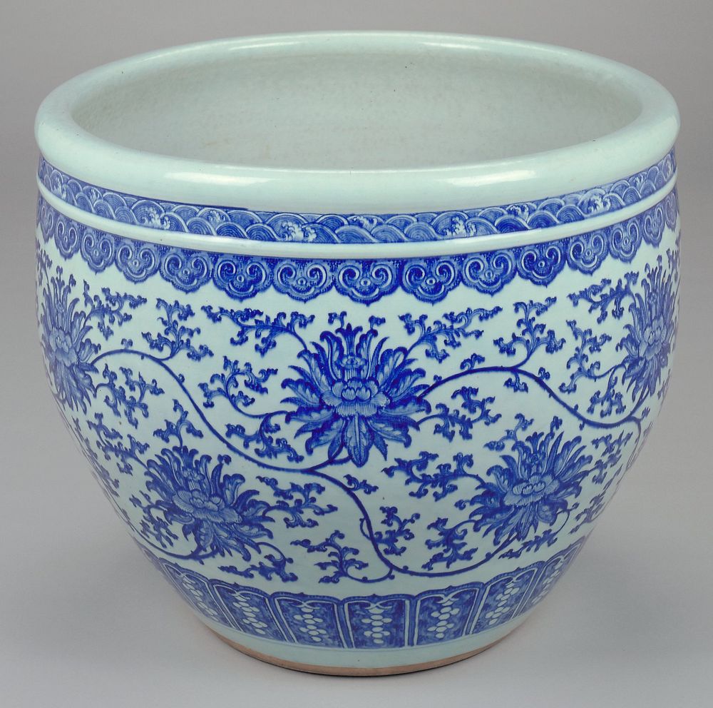 large blue and white porcelain jardiniere; two small bands at rim top being a wave pattern; large band at body of flowers…