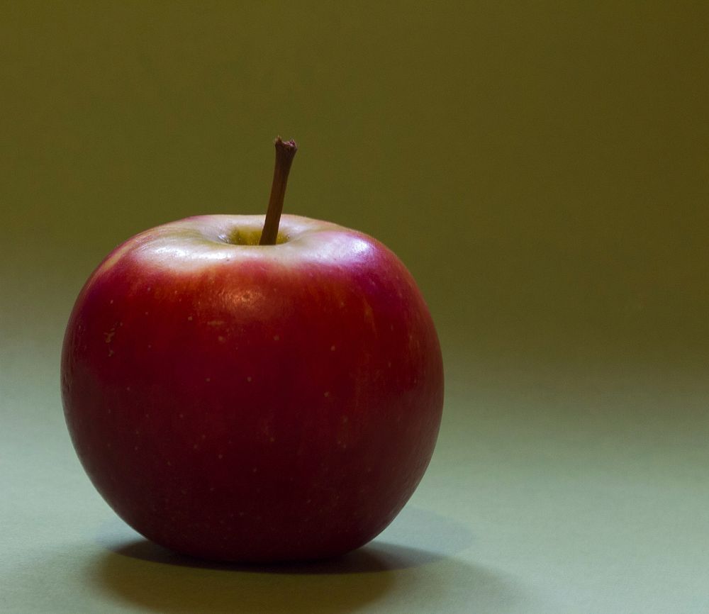 Closeup on red apple on wooden table. Free public domain CC0 photo.