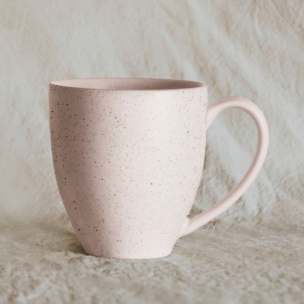 Pink handmade coffee mug on beige 