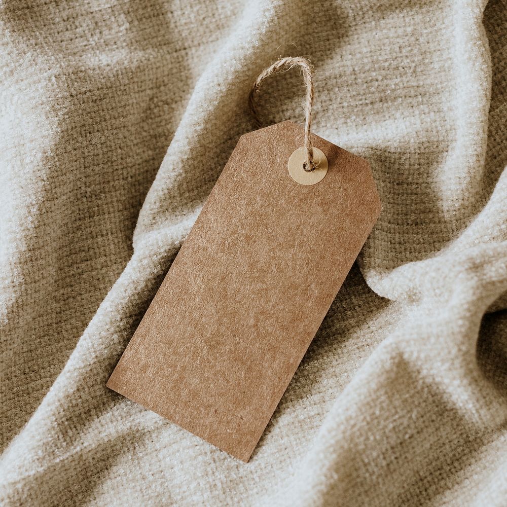Blank paper tag on soft beige fabric