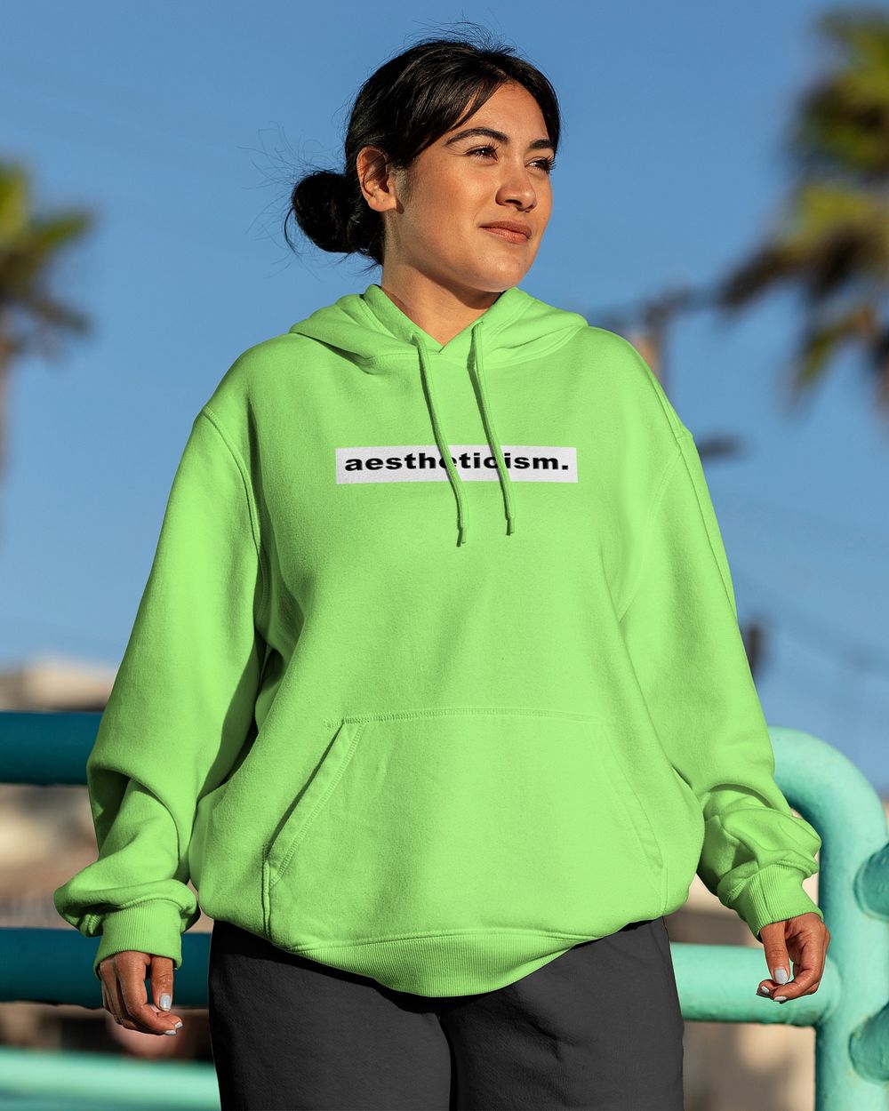 Woman wearing a streetwear hoodie, neon green design with aestheticism text