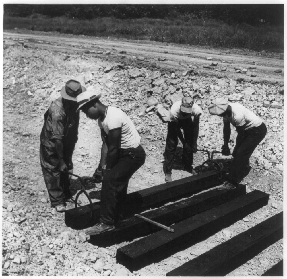  laborers carrying and laying railroad ties for a spur line into a coal storage space for the federal government. Sourced…