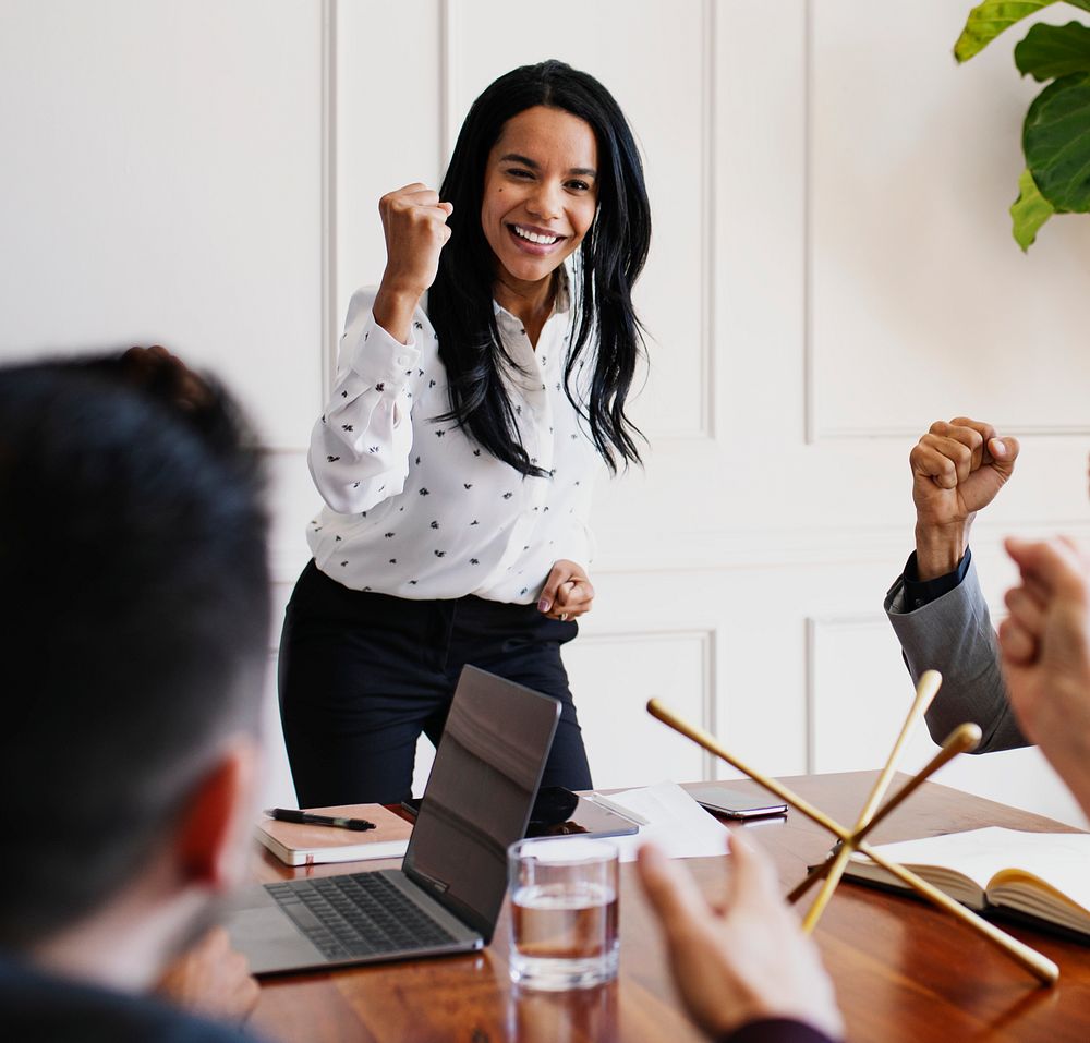 Businesswoman motivating her team members in a meeting