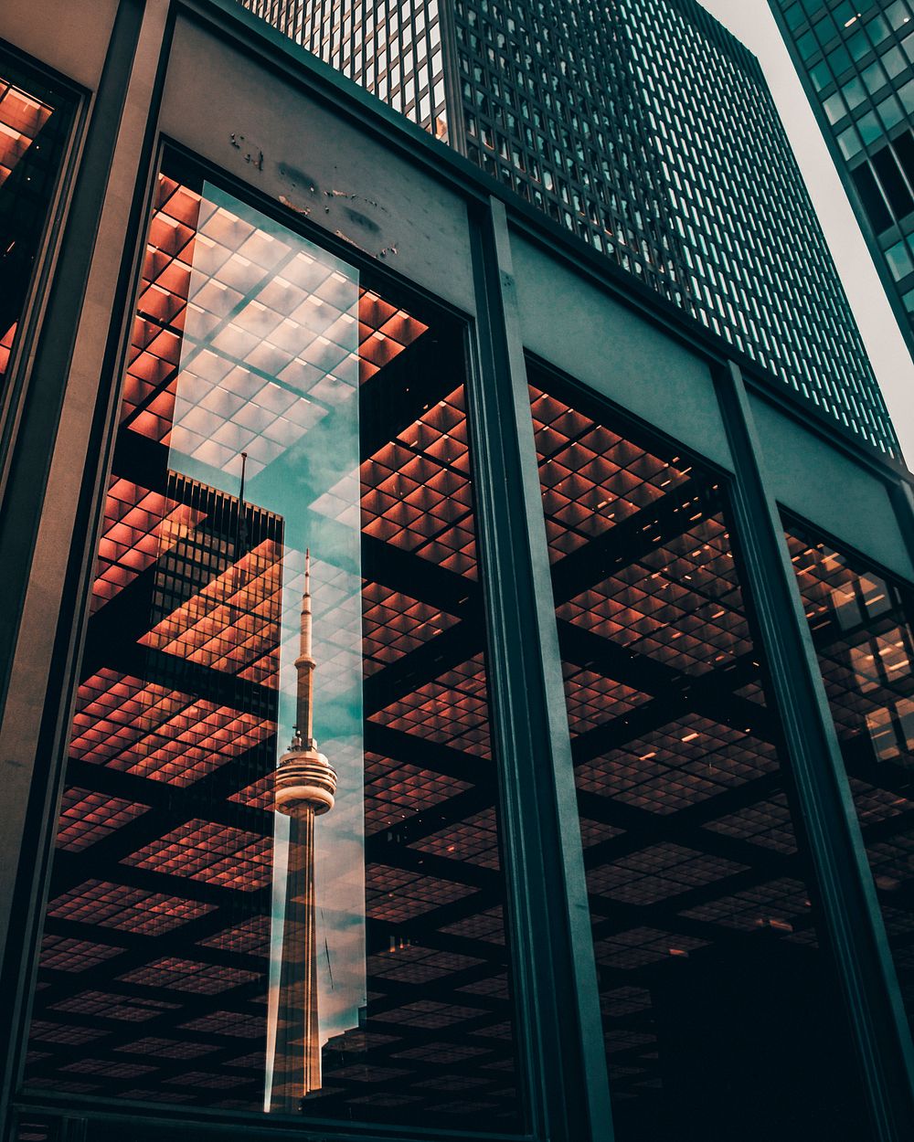 The CN Tower in Toronto reflected in the window of a nearby building. Original public domain image from Wikimedia Commons