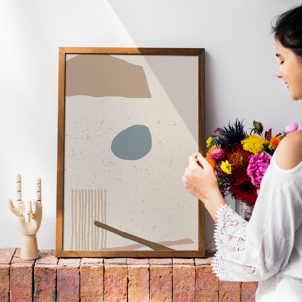 Girl decorating a wall with a frame mockup