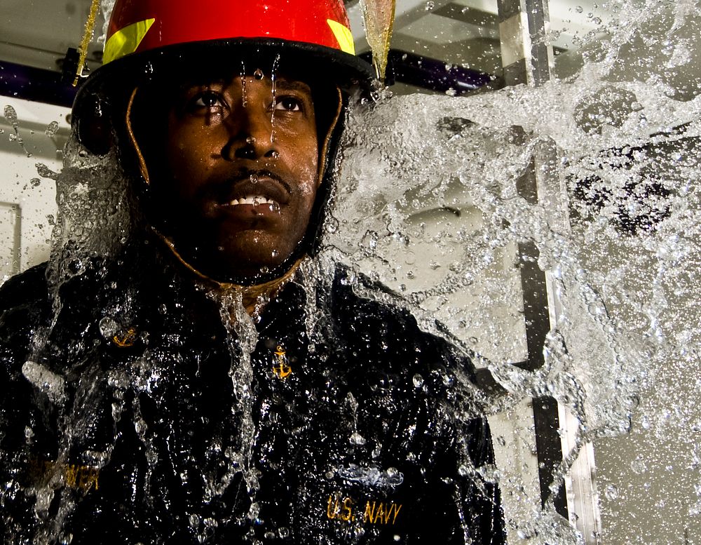 U.S. Navy Chief Damage Controlman Gregory Hightower demonstrates how to perform damage control procedures while inside a…