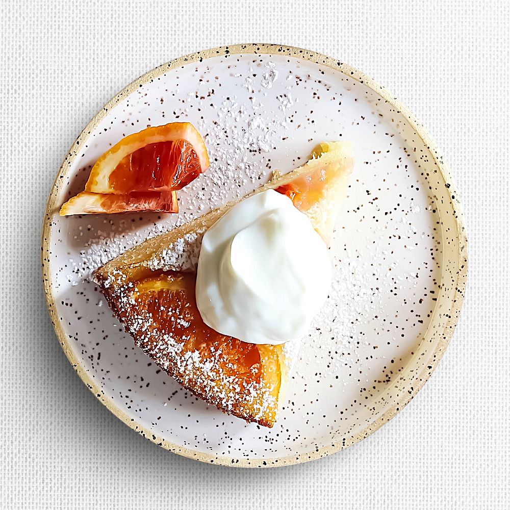 Orange cake slice on a plate, food photography, flat lay style