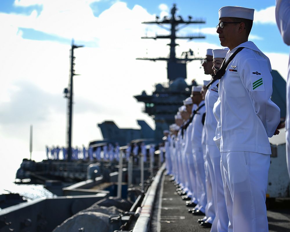 U.S. Sailors man the rails aboard the aircraft carrier USS Nimitz (CVN 68) as the ship prepares to moor at Joint Base Pearl…