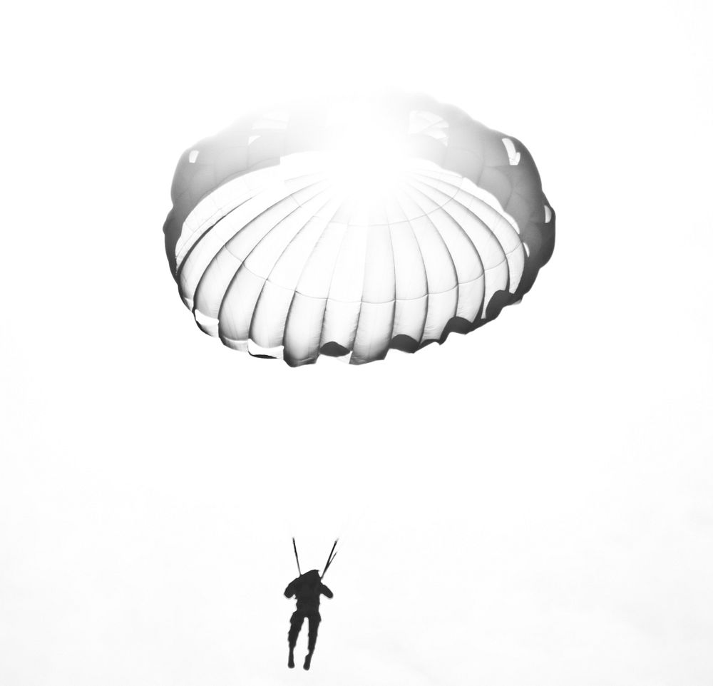 A U.S. Army Reserve paratrooper passes in front of the sun while parachuting during airborne operations at Coyle Drop Zone…
