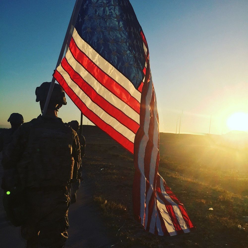 U.S. Army Sgt. Michael Swanker, assigned to the 1194th Engineer Company, 682nd Engineer Battalion, carries the American Flag…