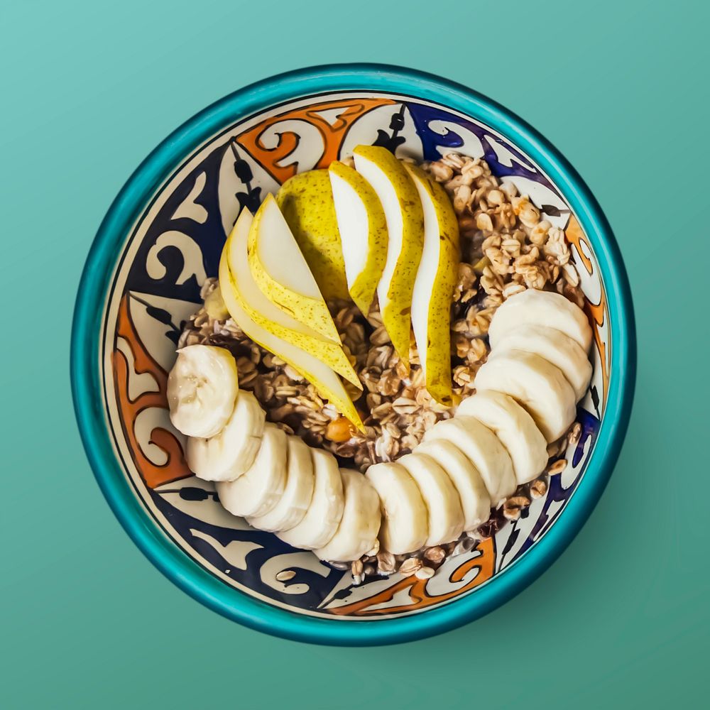Granola bowl on turquoise background, food photography, flat lay style