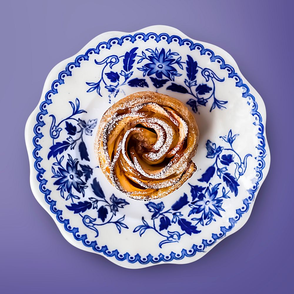 Apple rose on a plate, dessert on purple background, food photography