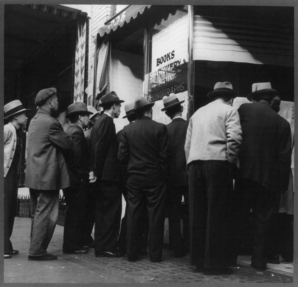 San Francisco, California. In front of the local paper at Chinatown. Chinese reading news of the surrender of Canton to the…