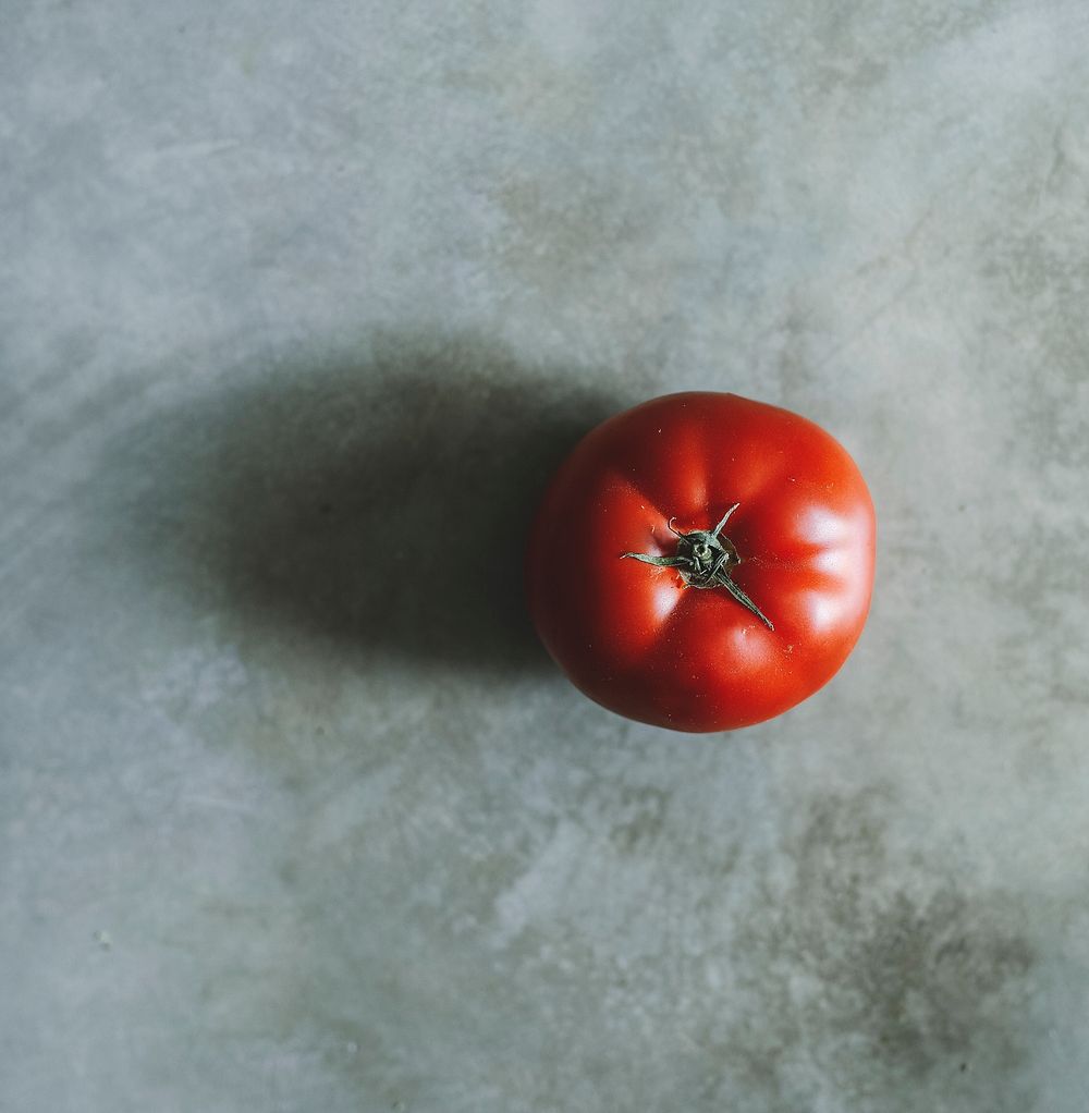 Red heirloom tomato on a gray background