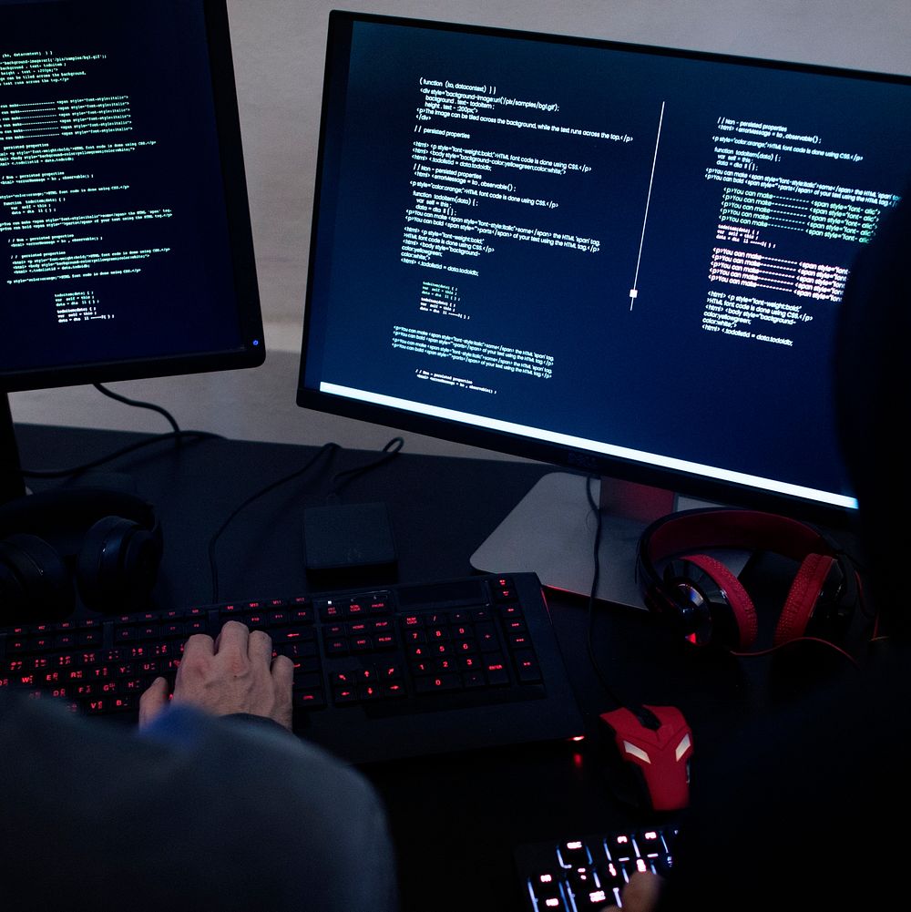 Hacker working on computer monitors