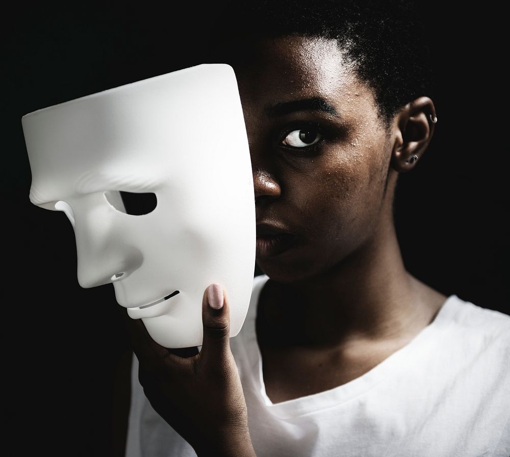 Thoughtful woman holding white mask