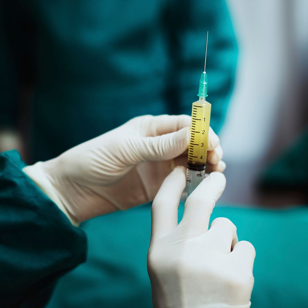 Doctor preparing a syringe shot for coronavirus patient