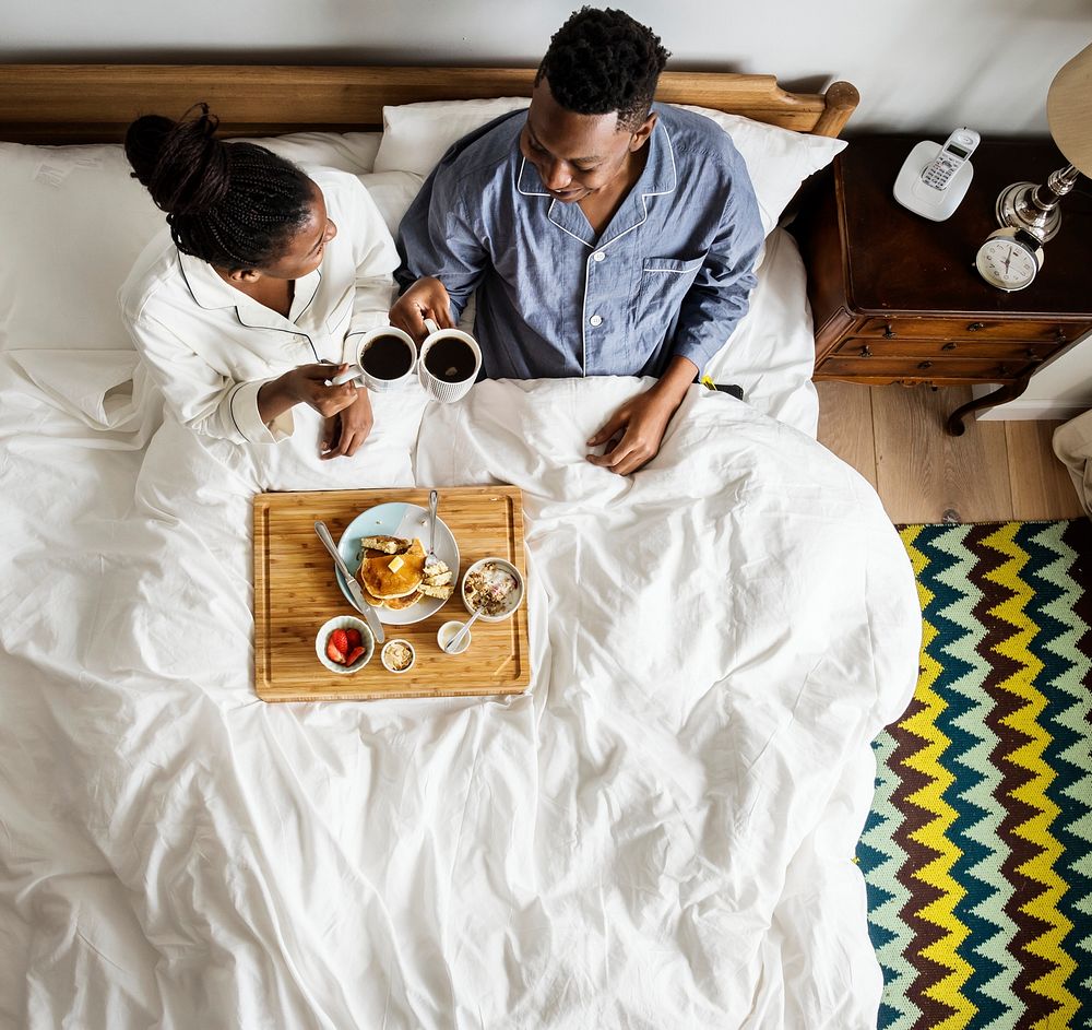 African American couple in bed having a breakfast in bed