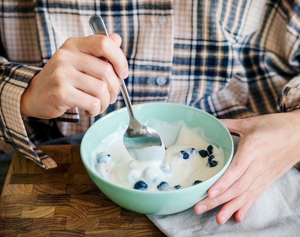 Caucasian girl eating yogurt on bed Premium Photo rawpixel