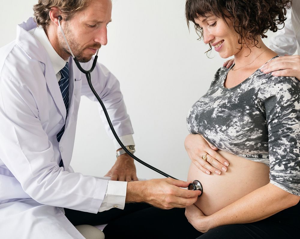 Pregnant woman having fetal monitoring by doctor