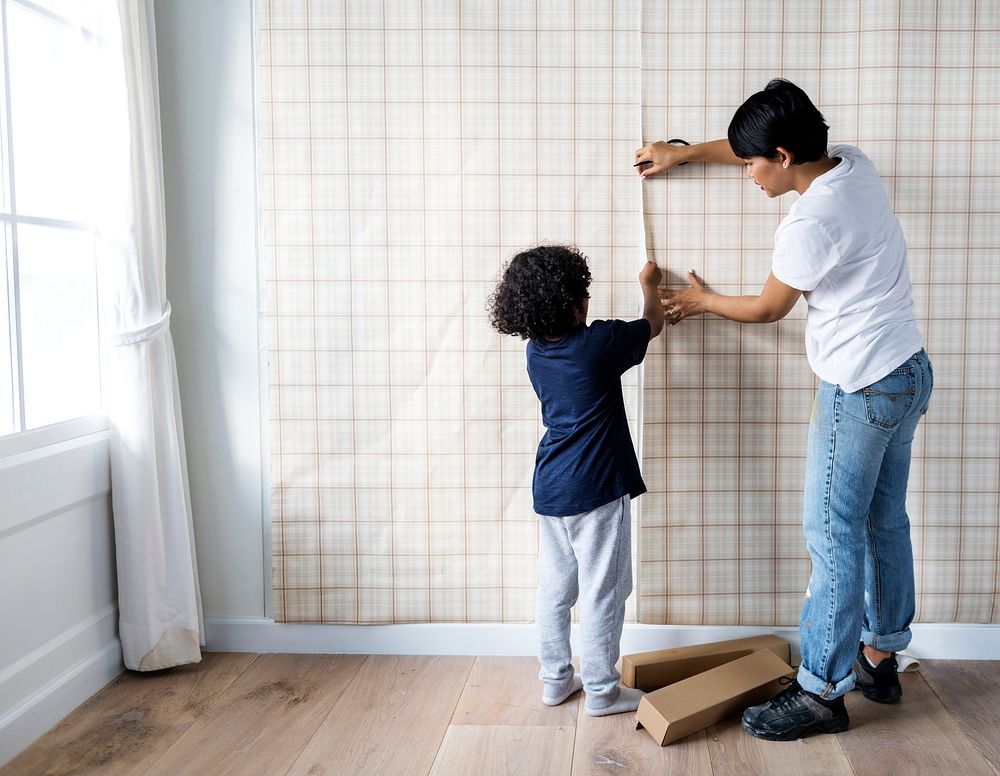 Kid helping mom install wallpaper