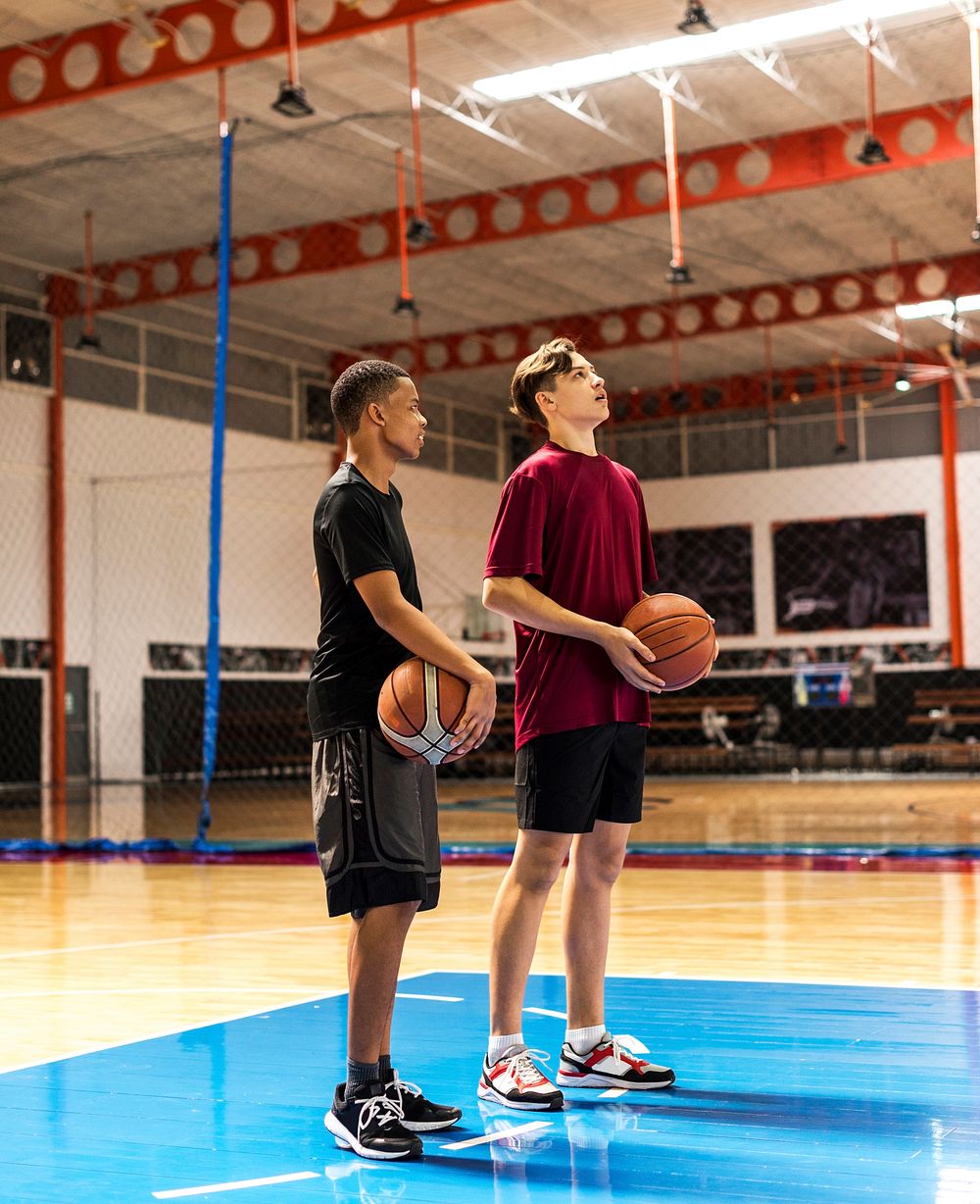 Teenage boys holding basketball on the court team and aspiration concept